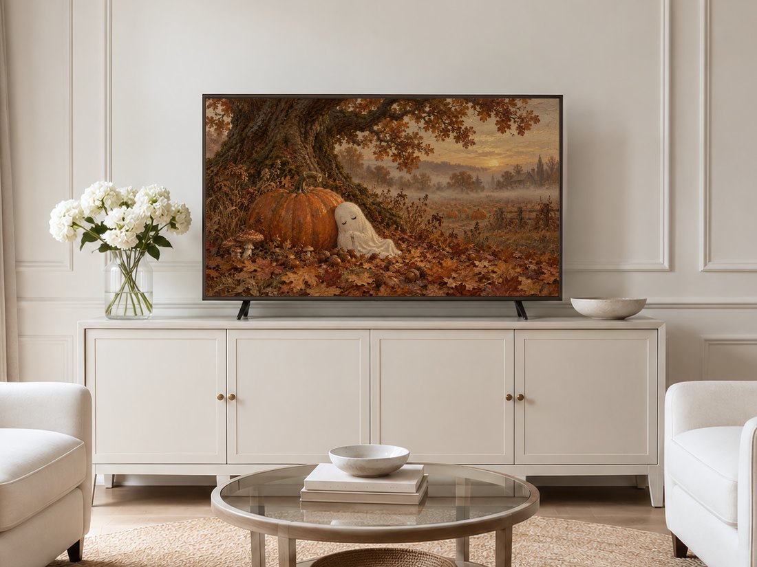 Antique autumn ghost landscape displayed on Frame TV above cream panelled wall in a neutral living room with cream sideboard, white hydrangeas and pale armchairs.