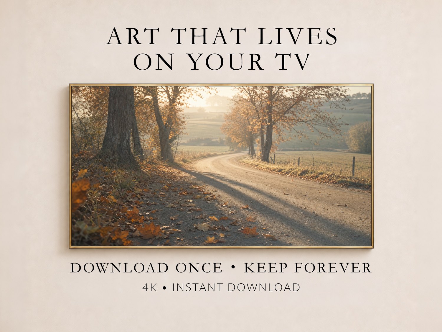 Autumn country road artwork with scattered rust and gold leaves shown in a thin gold frame on a soft cream wall, illustrating Frame TV art you download once and keep forever in 4K.