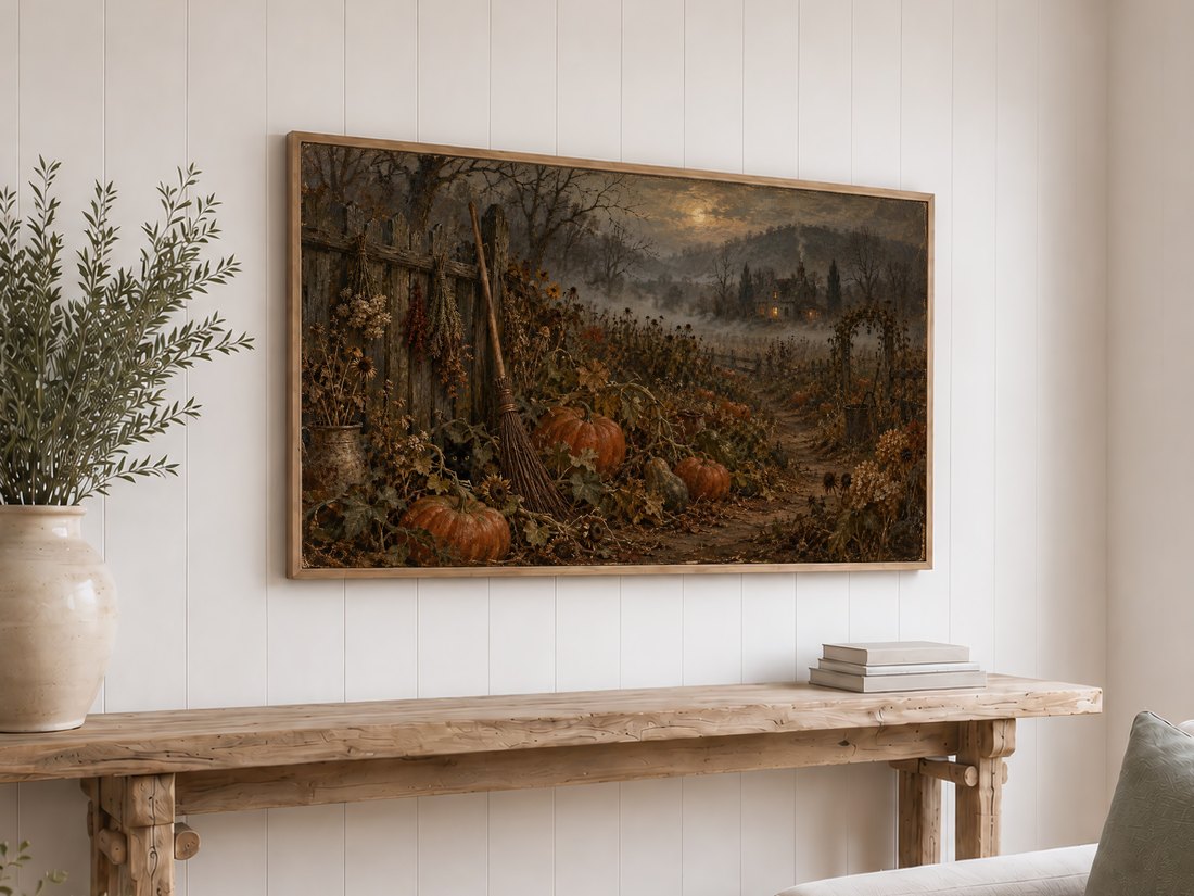 Atmospheric autumn Frame TV art hung above a reclaimed-wood console table on white shiplap, with cream ceramic vase and olive branches in a coastal farmhouse bedroom.