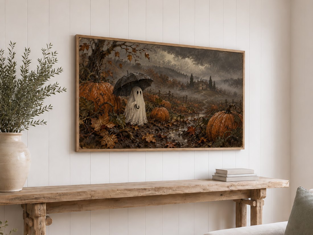 Frame TV art showing a ghost with umbrella in moody pumpkin field displayed above a rustic reclaimed-wood console table on white shiplap, styled with olive branches and neutral books.
