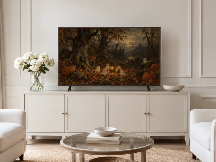 Halloween forest frame TV art displayed on a cream panelled wall in a neutral living room above a cream sideboard with white hydrangeas and brass accents.
