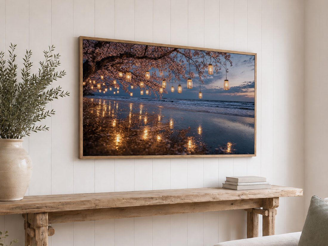 Cherry blossom and lantern reflection art on a Frame TV in a light oak frame above a rustic reclaimed wood console, set against a white shiplap wall with olive branches in a cream ceramic vase and stacked neutral books.