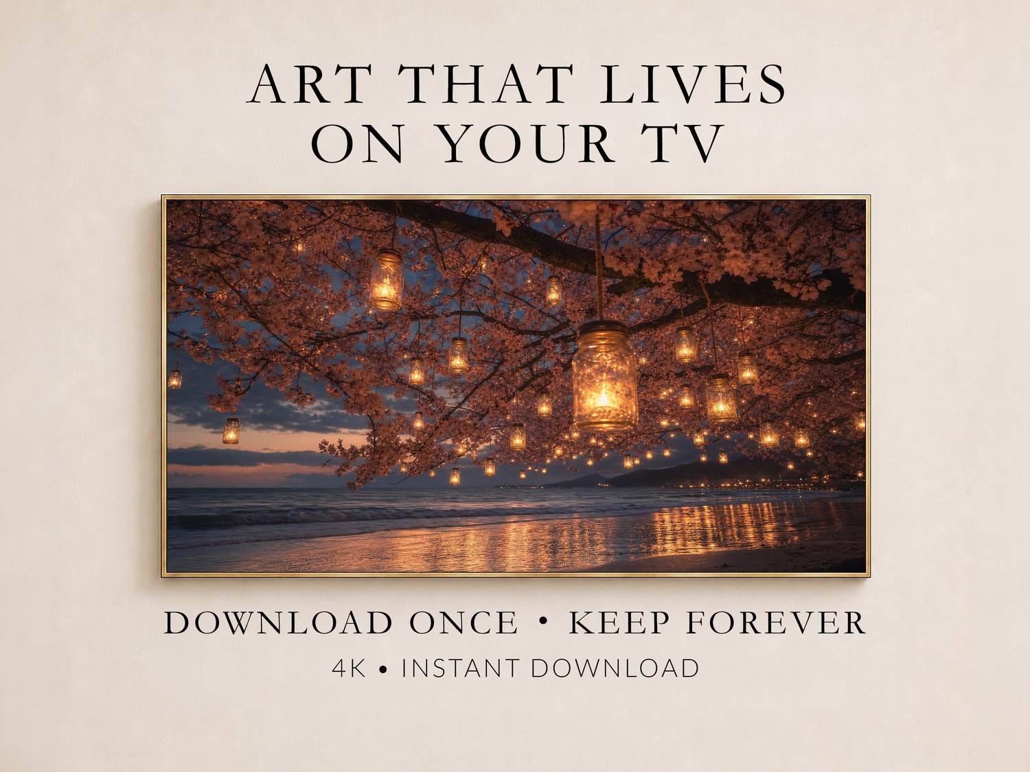 Cherry blossom lantern beach scene displayed on a Frame TV in a thin gold frame against a soft cream wall, glowing mason jar lights hanging among pink blossoms above dark ocean water at dusk.