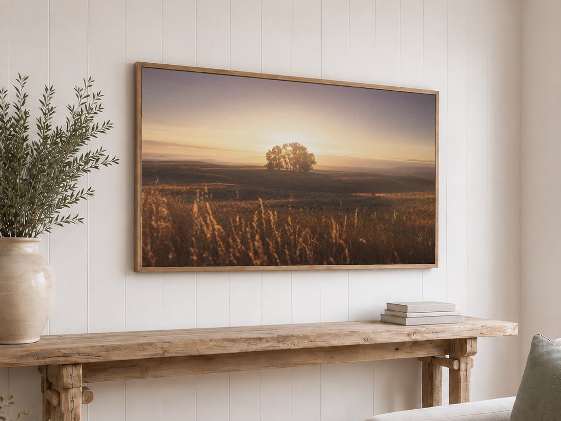 White shiplap wall featuring the meadow landscape on a light oak Frame TV above a reclaimed-wood console table topped with olive branches in a cream ceramic vase and neutral books.