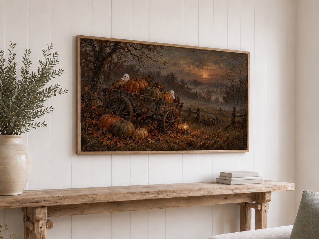 Moody haunted pumpkin patch scene with ghosts and glowing lantern shown on a Frame TV above a reclaimed-wood console table on a white shiplap wall, styled with olive branches and neutral books.