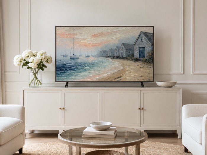 Coastal boathouse and sailboat painting shown on a Frame TV in a neutral living room with a cream sideboard, white hydrangeas and a jute rug, adding a soft nautical mood to the space.