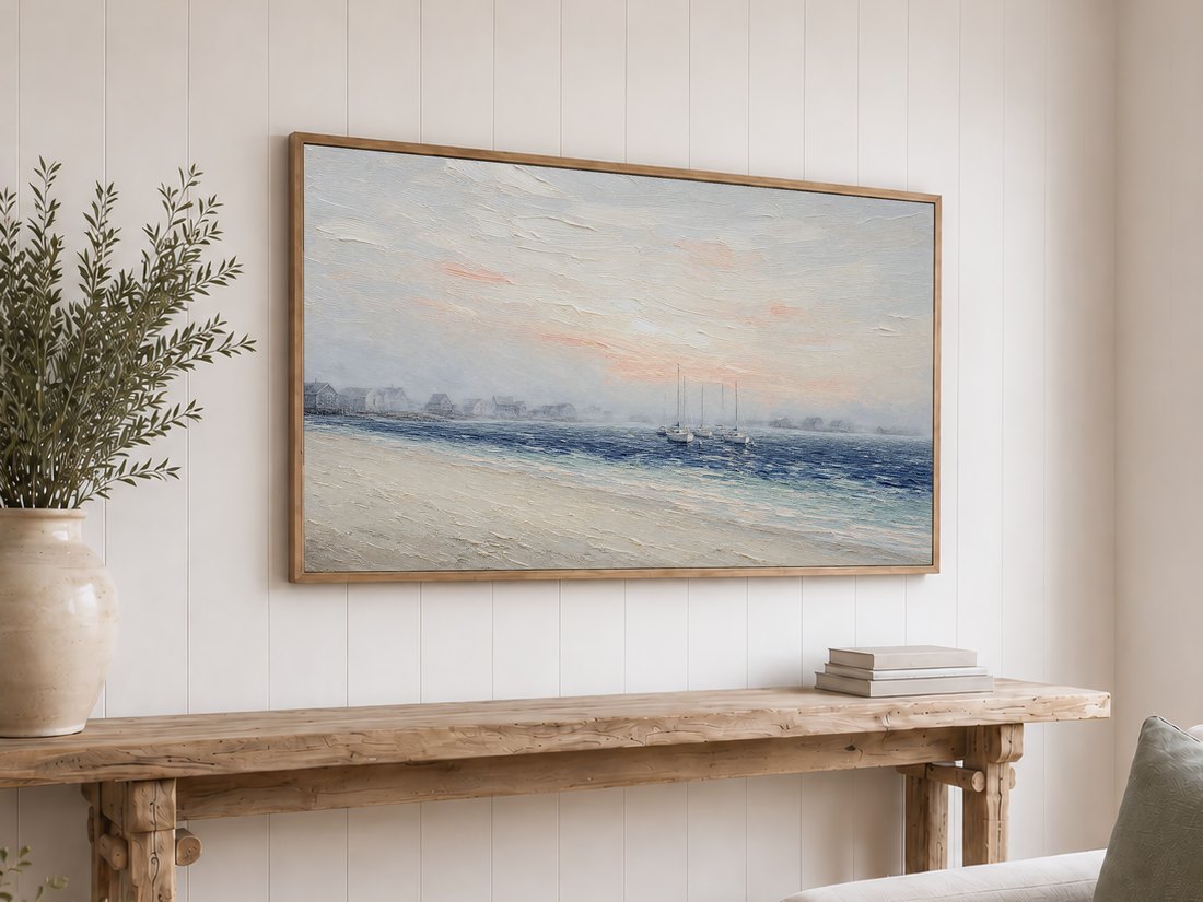 Foggy harbor sailboat painting on a light oak framed TV above a reclaimed-wood console with olive branches and neutral books, giving a coastal accent to a white shiplap wall.