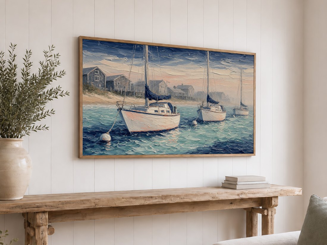 Nautical harbor scene on a light oak framed Frame TV above a rustic reclaimed-wood console with olive branches in a cream vase and stacked neutral books, set against a white shiplap wall for a relaxed coastal cottage look.