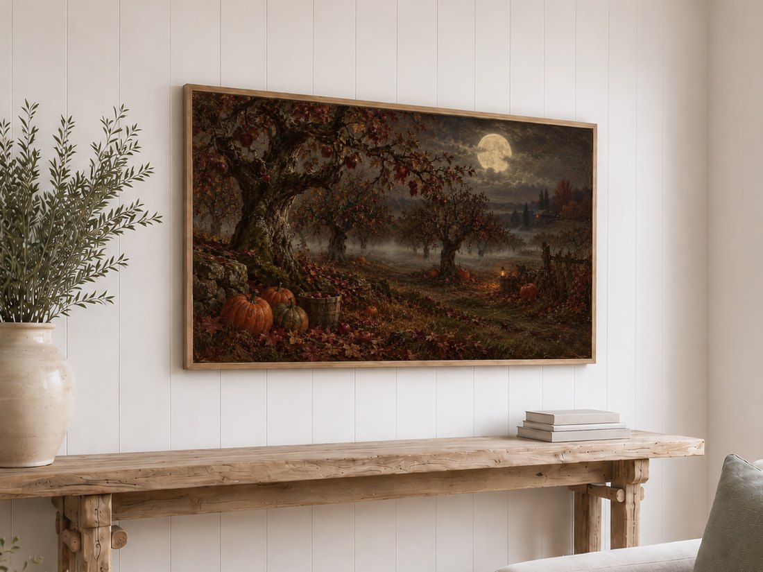 Moonlit Apple Orchard Frame TV Art mounted above a rustic reclaimed-wood console table on a white shiplap wall, styled with olive branches in a cream ceramic vase and neutral books.