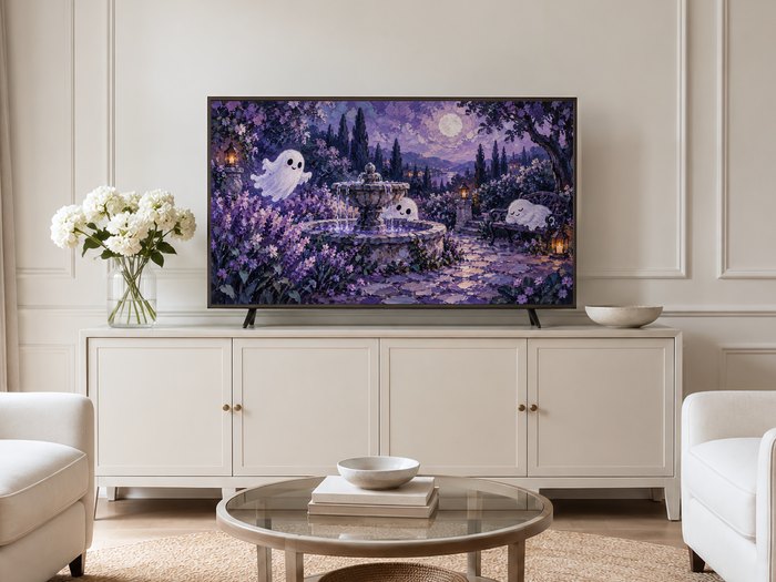 Whimsical purple moonlit ghost garden frame TV art displayed on a neutral living room wall with cream panelling, above a long cream sideboard with brass knobs, white hydrangeas and a round glass coffee table.